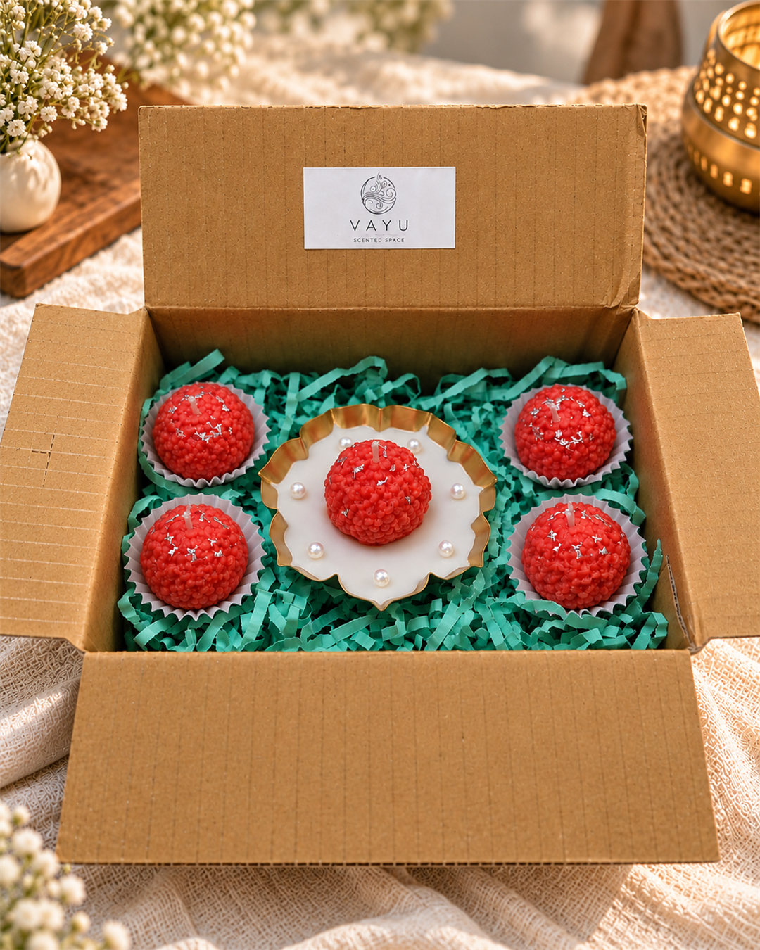 Five laddu-shaped candles with silver highlights and a pearl-trimmed display dish in a Vayu hamper box