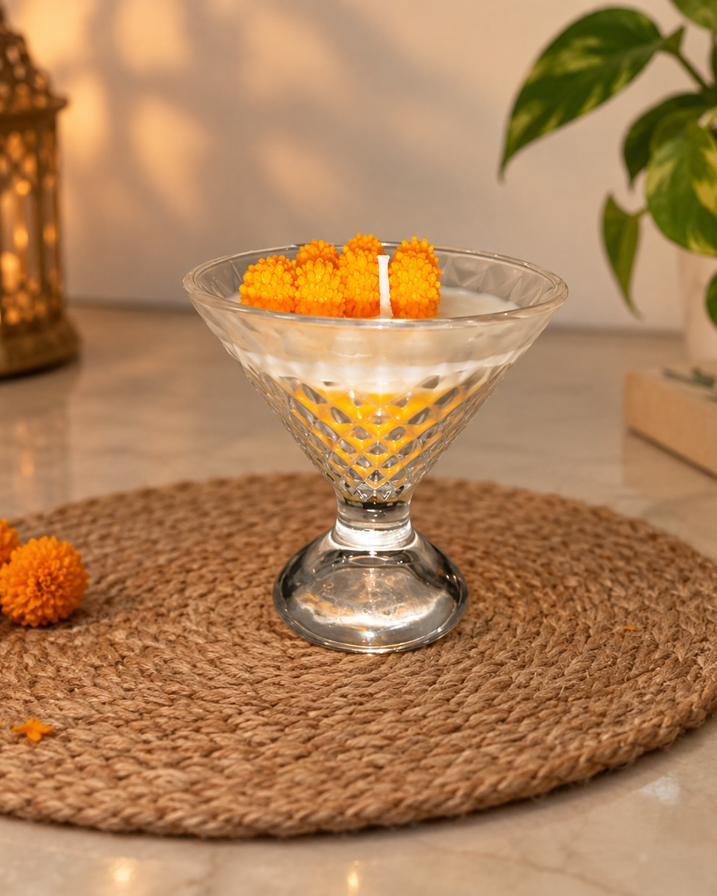 Dessert candle with orange wax flowers in a cut-glass vessel