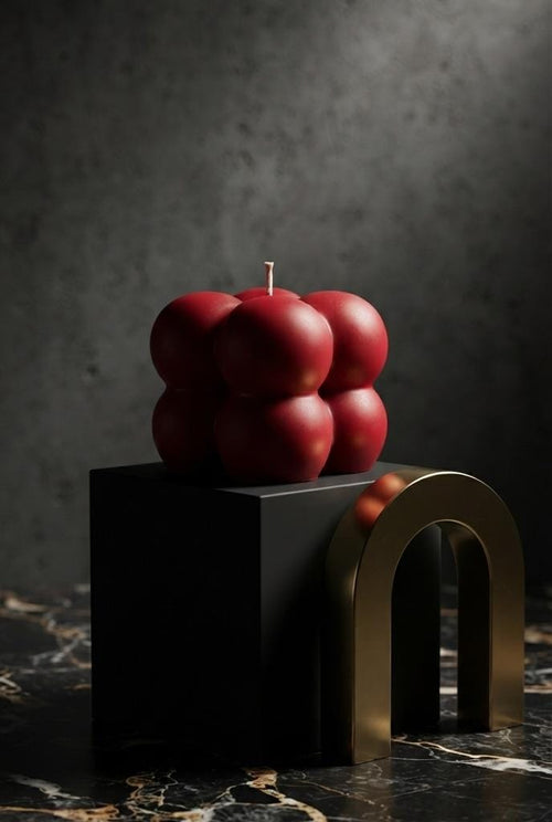 Small red Bubble candle on a dark geometric display